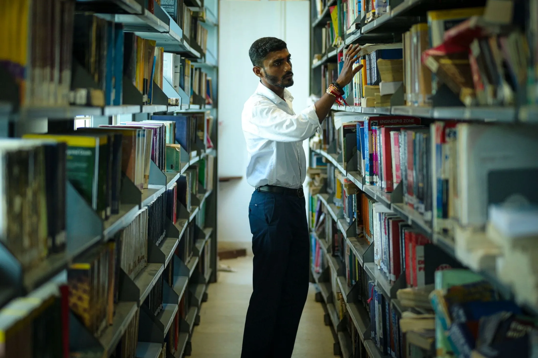 Student searching the shelves of a university library