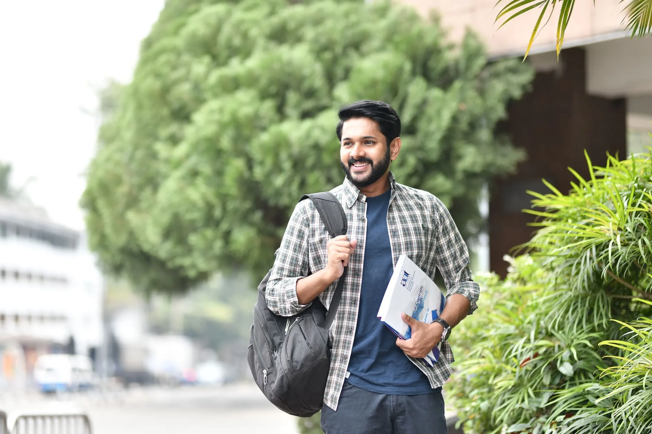 Student with a backpack and books walking outdoors